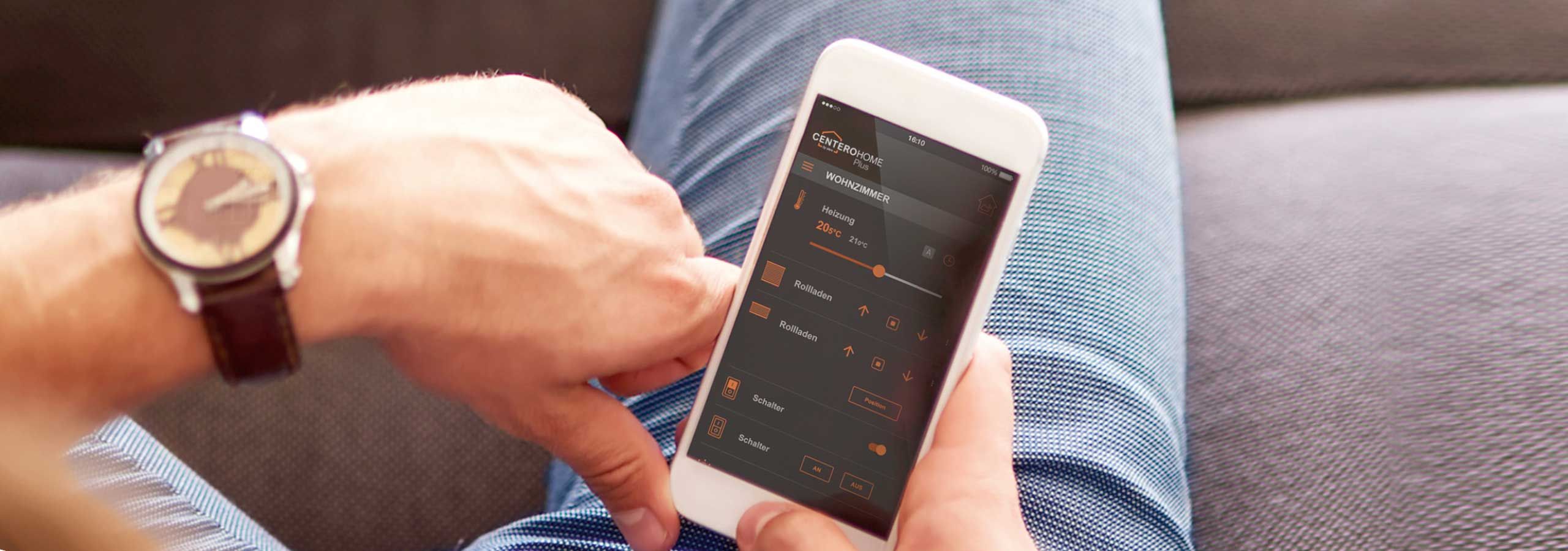 Mann mit Handy steuert Smart Home in Bruchsal